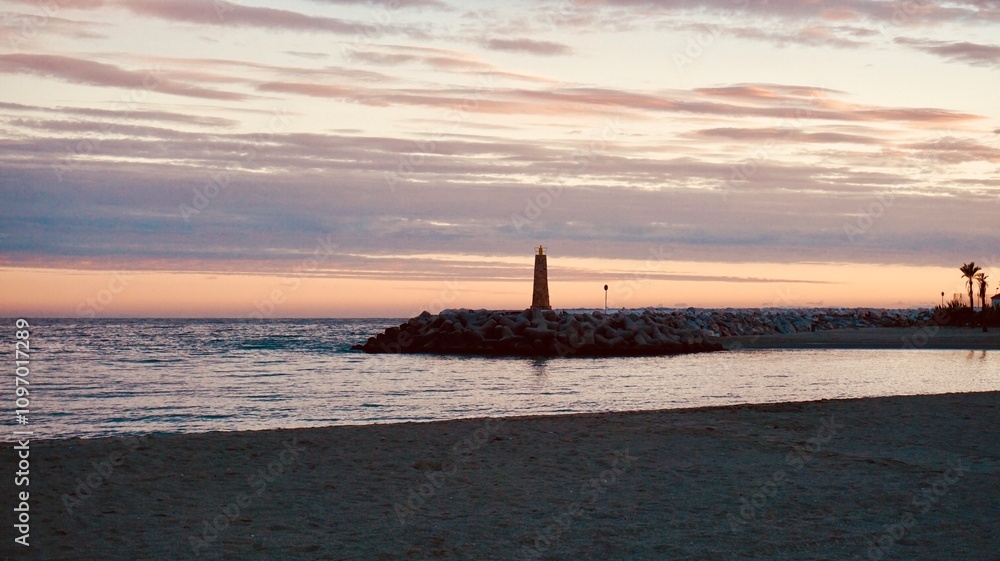 Fototapeta premium Coastal Sunset with Breakwater Lighthouse and Calm Ocean