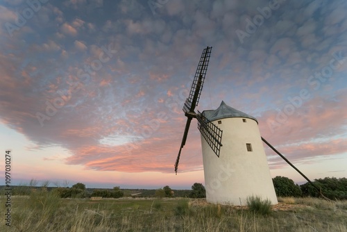 Windmill at sunset in a place of the spot called Vinuelas with pink sky ( Guadalajara ) Spain photo