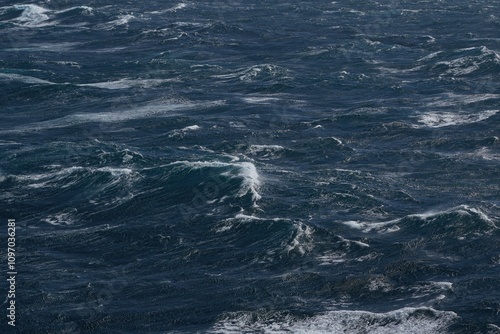 Dark ocean waves with white foam creating dynamic seascape. turbulent water reflects sense of power and movement, showcasing nature raw beauty