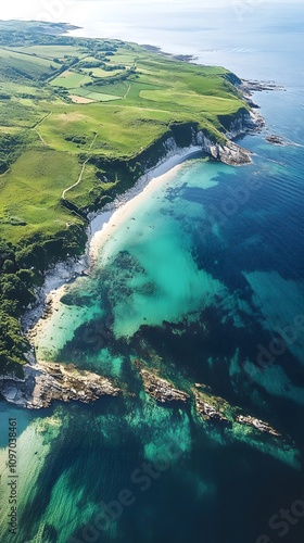 Aerial view of a serene coastline with lush greenery and clear turquoise waters.