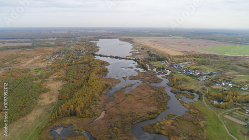 Large body of water is surrounded by trees and grass photo