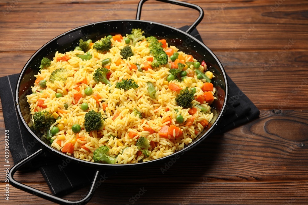 Tasty rice with vegetables in baking dish on wooden table, closeup Tasty rice with vegetables in baking dish on wooden table, closeup