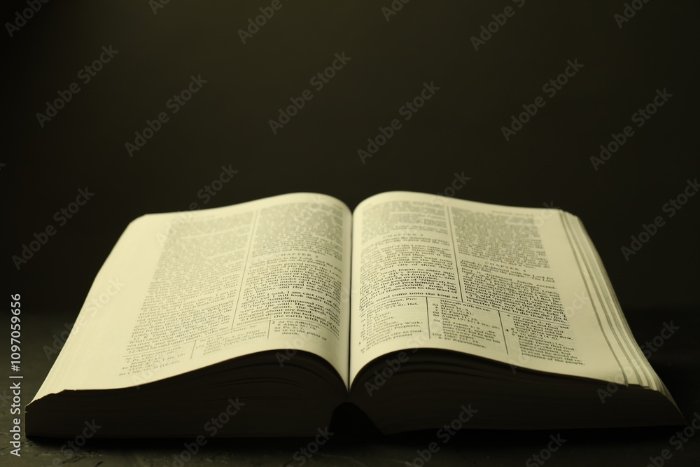 Open Holy Bible in English language on black table, closeup Open Holy Bible in English language on black table, closeup