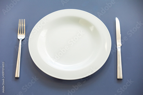 Empty plate top view with metal cutlery next to it