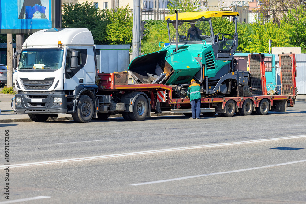 Heavy machinery transportation on a bustling city street in broad daylight. Copy space.