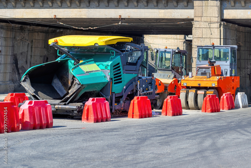 Construction machinery at work beneath a bridge during a sunny day. Copy space.
