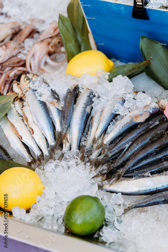Photos Fresh sardines on ice with lemon and lime garnish, perfect for gourmet cooking a