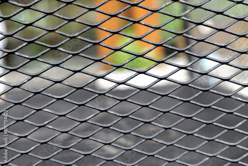 Close-up of a metal mesh fence, showcasing its intricate design and background colors.