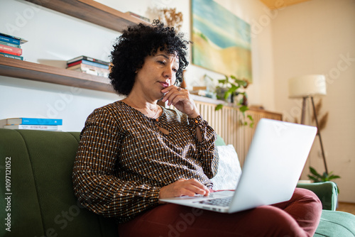 Frustrated woman on video call working from home on laptop photo