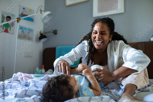 Mother playing and laughing with her baby at home photo