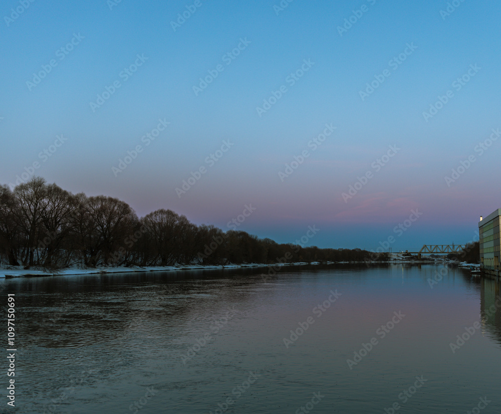 A calm river with a beautiful blue sky in the background A calm river with a beautiful blue sky in the background