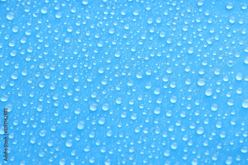 Water drops on blue background, top view