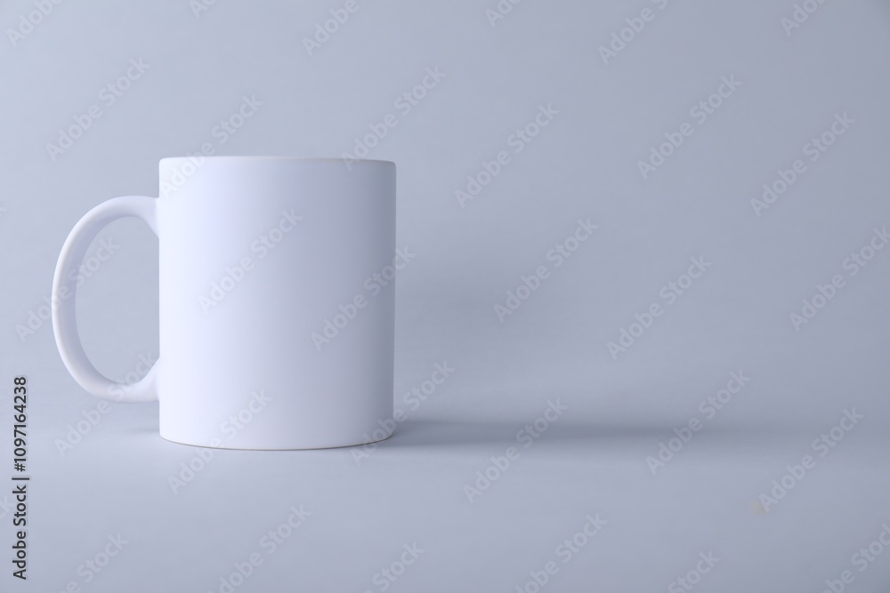 One blank white mug on light background. Mockup for design One blank white mug on light background. Mockup for design