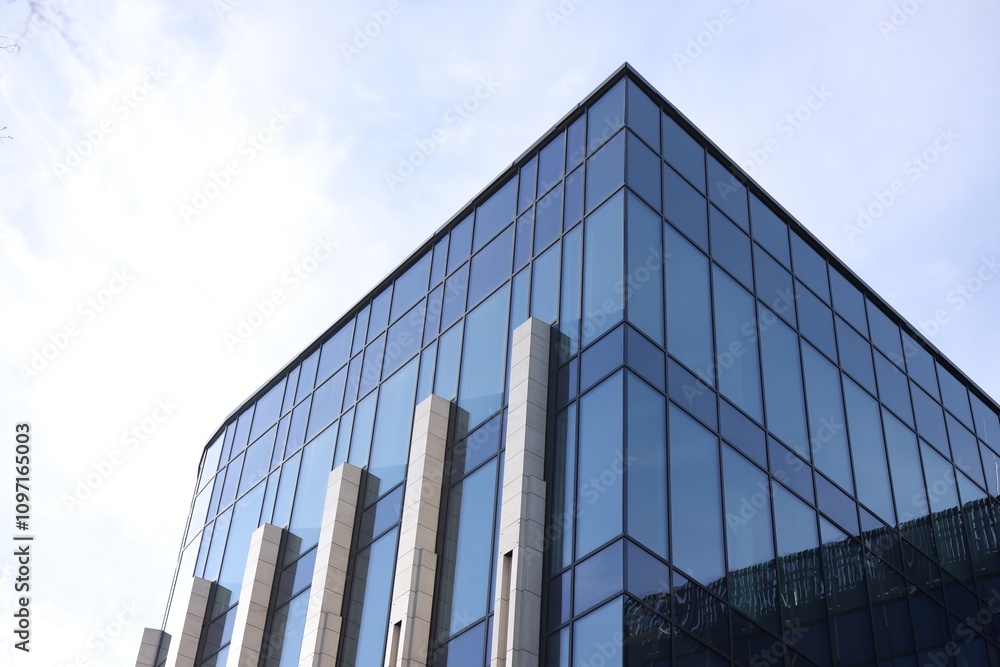 Fototapeta premium Exterior of modern building with many windows outdoors, low angle view