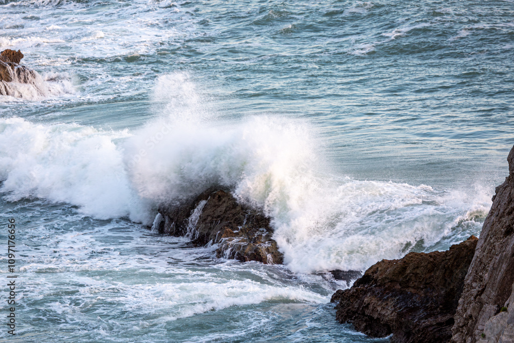 Fototapeta premium Rocks in the Man O War bay being hit by large waves at sunset
