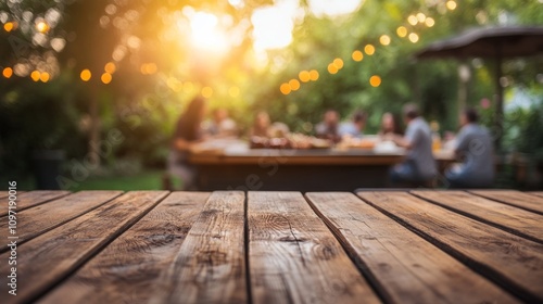 Empty wooden table and blurred view of a group of people having BBQ barbecue outdoors. Wood desk in front of a natural garden background