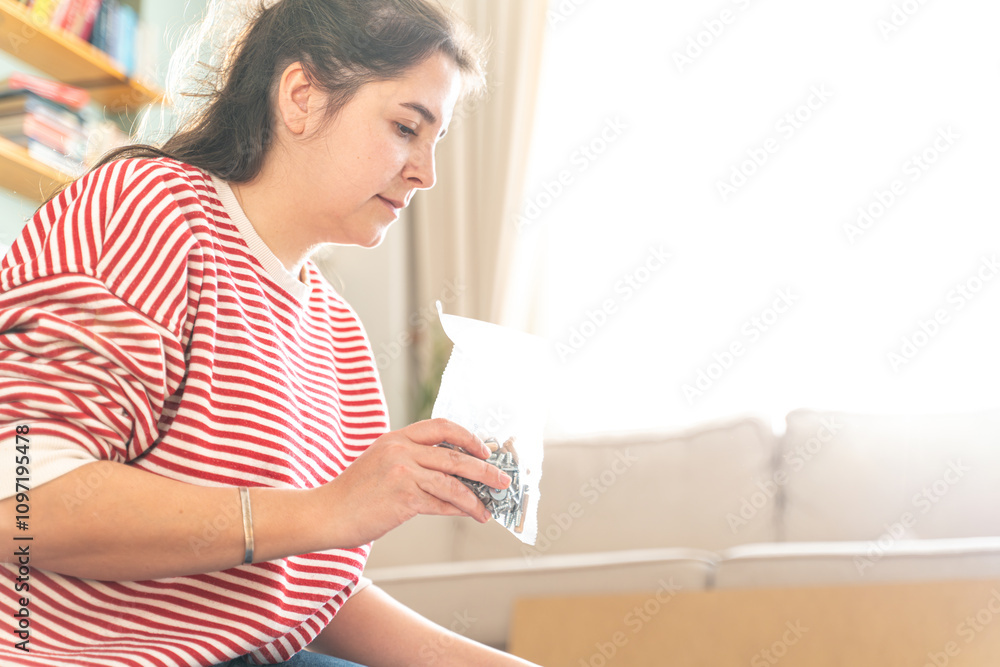 Beautiful Young happy woman in a new home who assembles furniture for self-assembly. DIY concept Beautiful Young happy woman in a new home who assembles furniture for self-assembly. DIY concept