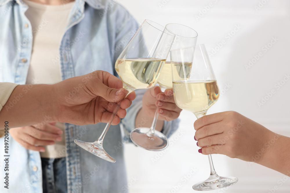 People clinking glasses of wine indoors, closeup People clinking glasses of wine indoors, closeup