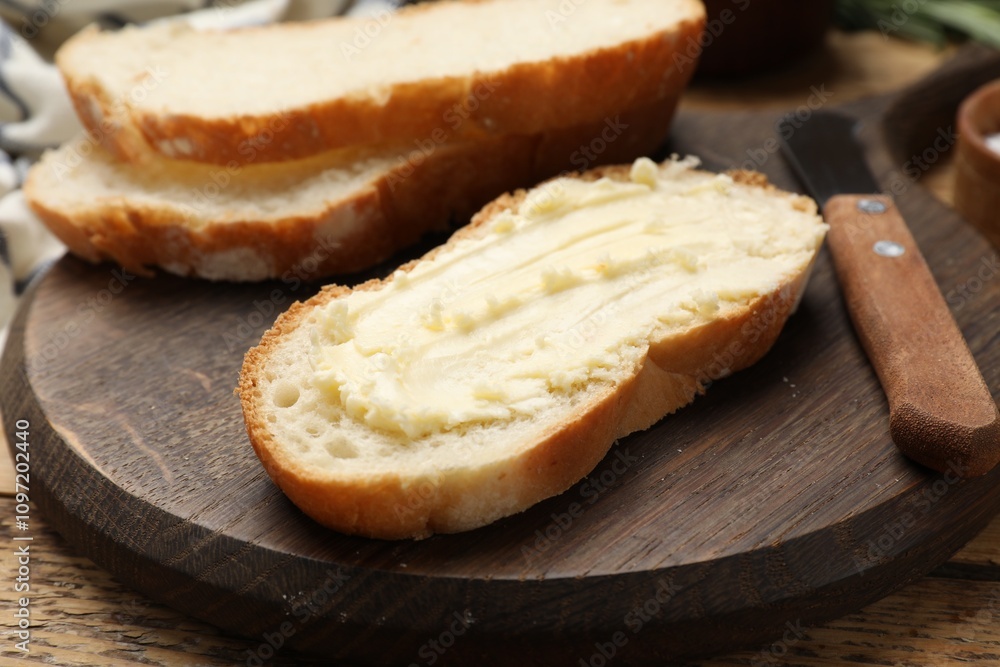 Fresh bread with butter and knife on wooden table, closeup Fresh bread with butter and knife on wooden table, closeup