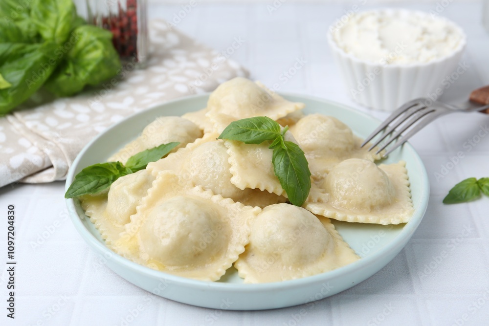 Delicious ravioli with cheese and basil served on white tiled table, closeup Delicious ravioli with cheese and basil served on white tiled table, closeup