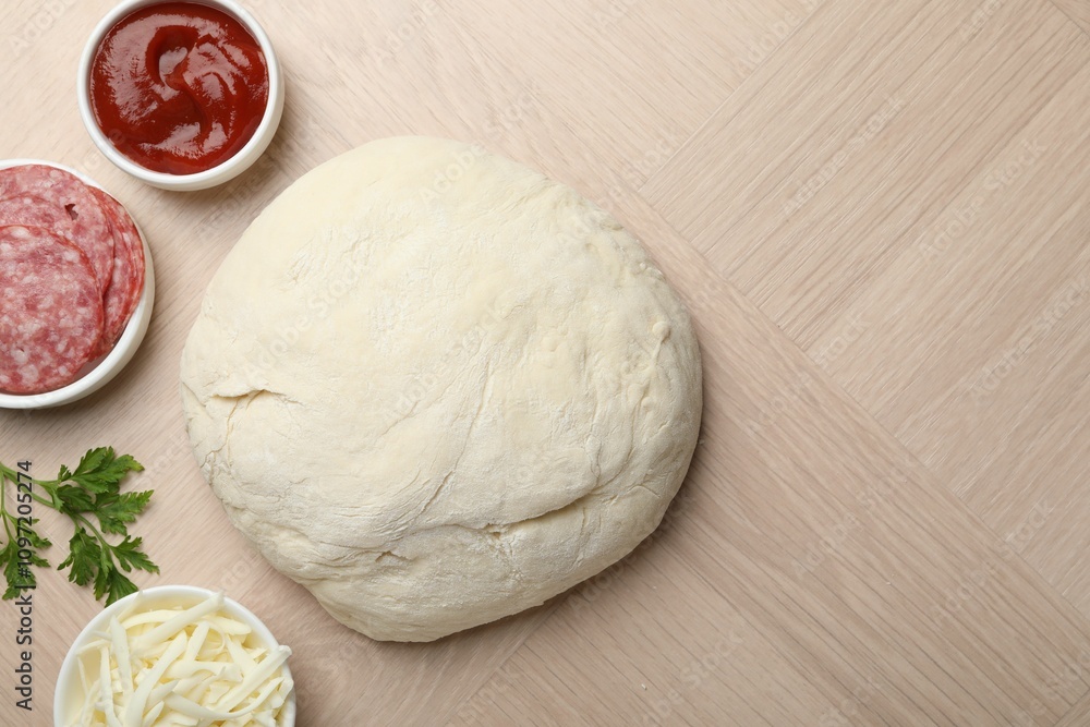Making calzone pizza. Dough and ingredients on wooden table, flat lay. Space for text Making calzone pizza. Dough and ingredients on wooden table, flat lay. Space for text