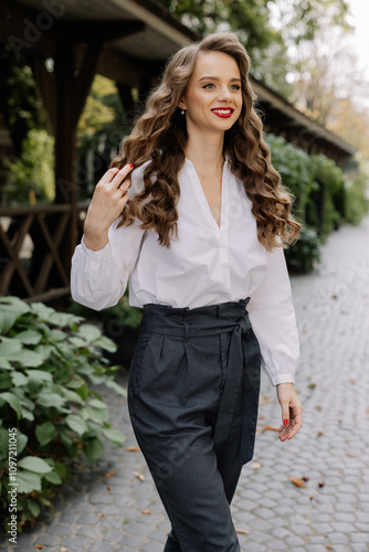 Businesswoman walking in a park touching her long brown hair