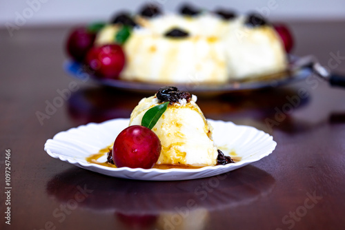 Traditional Brazilian coconut flan dessert known as manjar branco, manjar de coco and manjar dos deuses. Served with plum syrup. photo