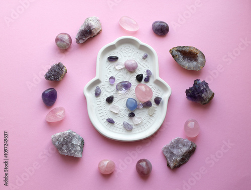 Pink healing chakras rose quartz and amethyst crystals. Stones are laid out on a plate. Real semi-precious stones healing crystals photo