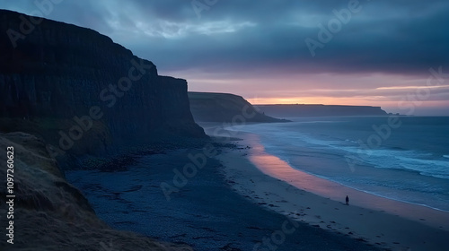 Dramatic sunset over a secluded beach with dark cliffs and a lone figure walking along the shore.