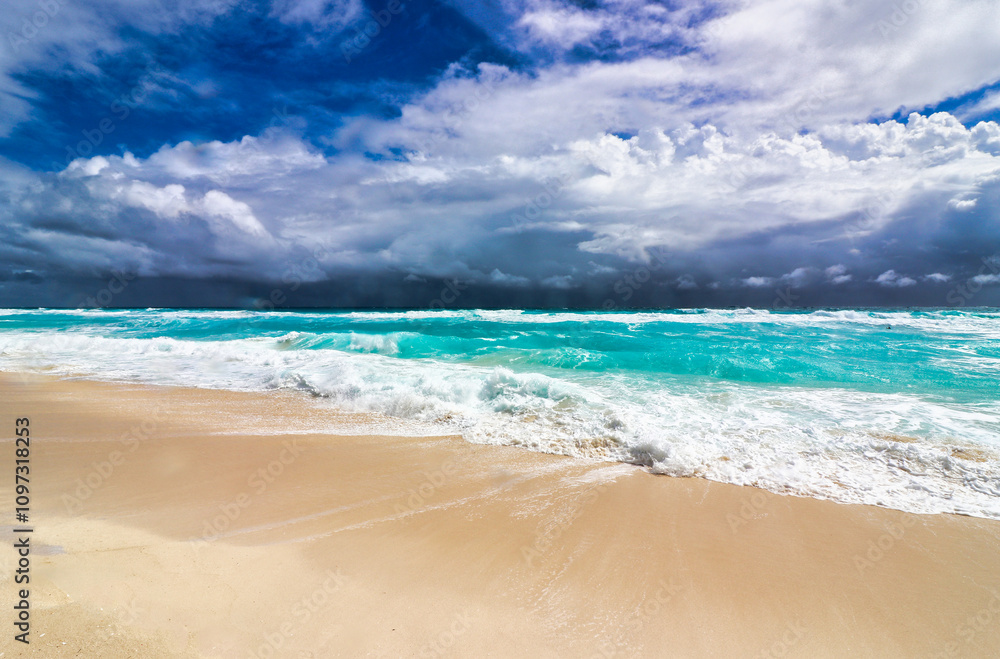 Storm clouds during the hurricane season present a dark sky over the turquoise blue waters and the beautiful Playa Delfines beach in the hotel zone of Cancun,Quintana Roo,Mexico Storm clouds during the hurricane season present a dark sky over the turquoise blue waters and the beautiful Playa Delfines beach in the hotel zone of Cancun,Quintana Roo,Mexico