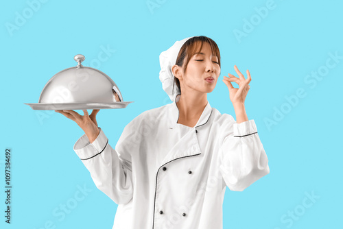 Female Asian chef with cloc...