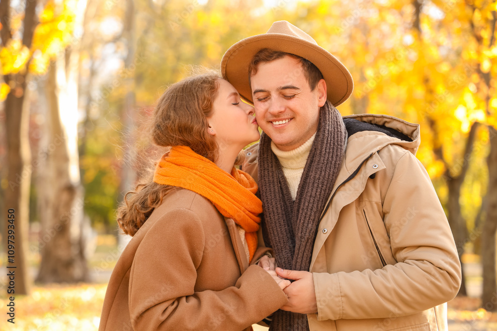 Fototapeta premium Beautiful loving young happy couple kissing in autumn park