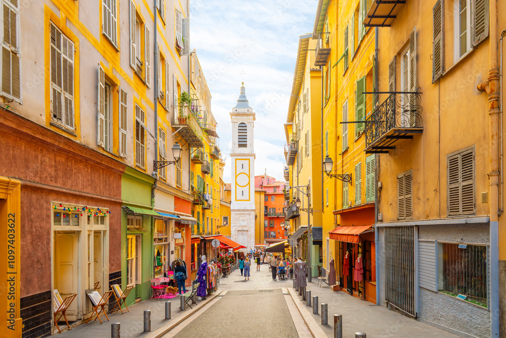 Fototapeta premium View of the campanile bell tower of the Nice Cathedral at Place Rossetti as tourists enjoy the narrow streets in the colorful Vieux Ville old town of Nice, France.