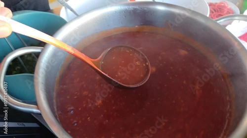 A cook is preparing crispy pork with rice, a popular Thai street food. 