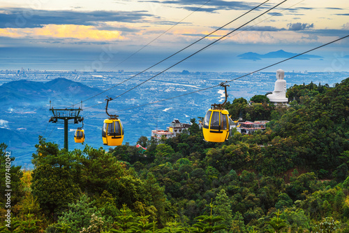 yellow cabanas of a funicular on a cable car in the mountains at the Ba Na Hills amusement park in Da Nang, Vietnam at sunset photo