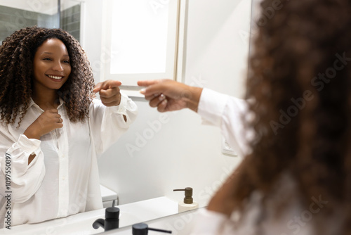 Photography Black woman motivates herself looking in mirror