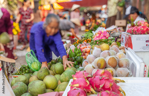 Blurred customers shopping for fruit on Hoi An Market, Vietnam photo