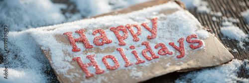 A festive holiday image featuring a snow-dusted brown paper sign with bright red 'Happy Holidays' text, embodying warmth and joyful celebration.