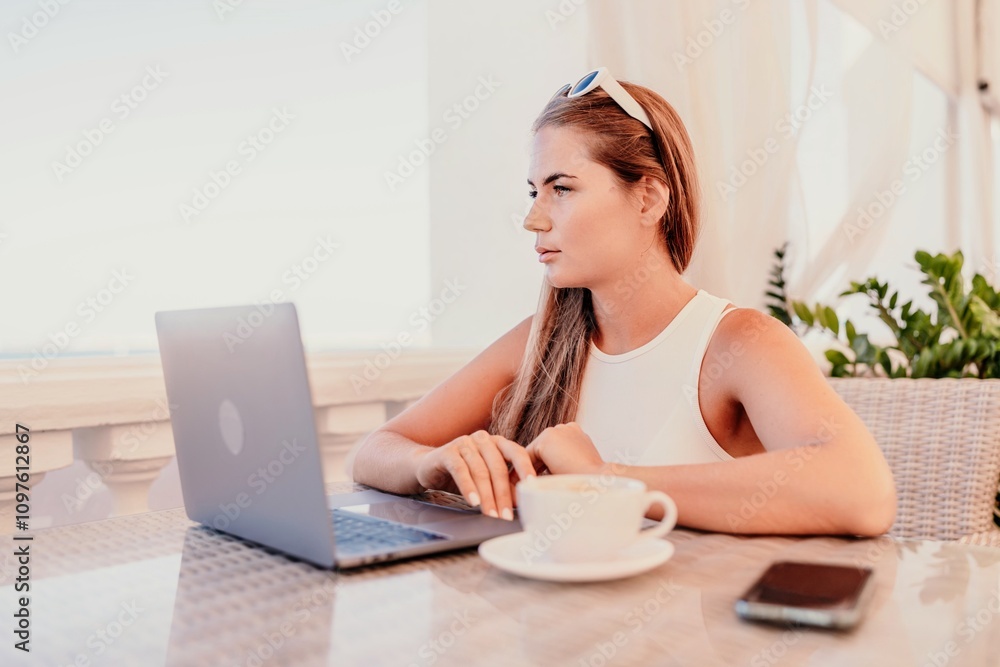 Woman coffee cafe laptop. Coffee break in cafe with sea view. Tranquil long haired woman drinking coffee in plant filled place. Woman sitting at a coffee shop with mobile phone drinking coffee. Woman coffee cafe laptop. Coffee break in cafe with sea view. Tranquil long haired woman drinking coffee in plant filled place. Woman sitting at a coffee shop with mobile phone drinking coffee.