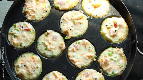 Appam or Mixed dal or Rava Appe South Indian dish preparation on iron pan photo