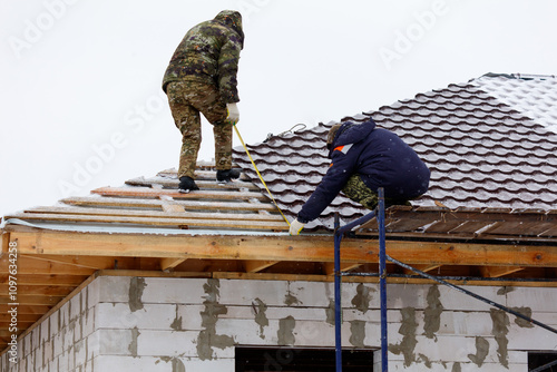 Wallpaper Mural Two men are working on a roof, one of them is using a tape measure Torontodigital.ca
