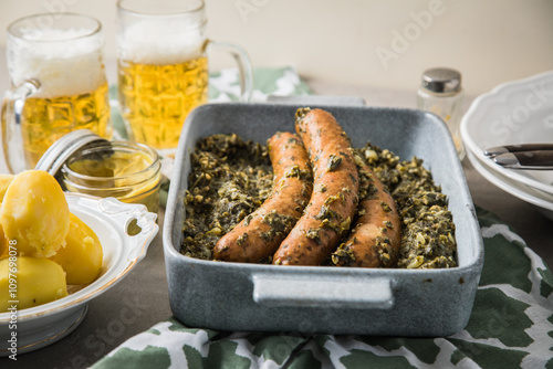 Wallpaper Mural Oldenburger Grünkohl mit Pinkel Kohlwurst in Schale, Salzkartoffeln, Senf und Bier auf gedeckten grau Tisch mit grün Tuch, Teller, Besteck rustikal  Torontodigital.ca