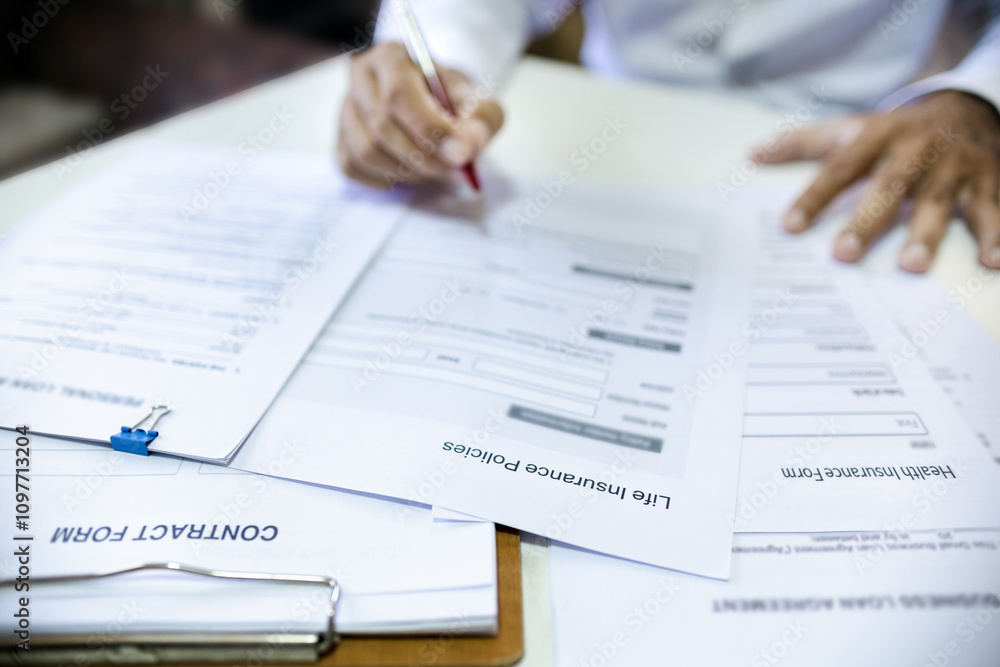 Blur hand of asian man reading contract making deal with life insurance agent before sign. concept for consultant health insurance, life insurance savings plan, select focus at document Blur hand of asian man reading contract making deal with life insurance agent before sign. concept for consultant health insurance, life insurance savings plan, select focus at document