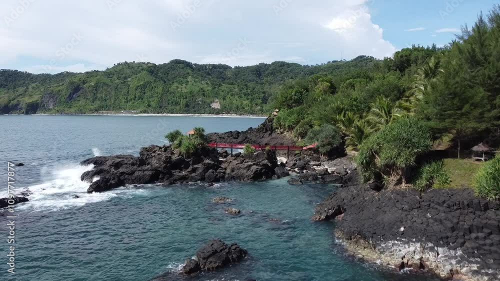 The red bridge connects 2 beaches with a rocky background. The red bridge connects 2 beaches with a rocky background.