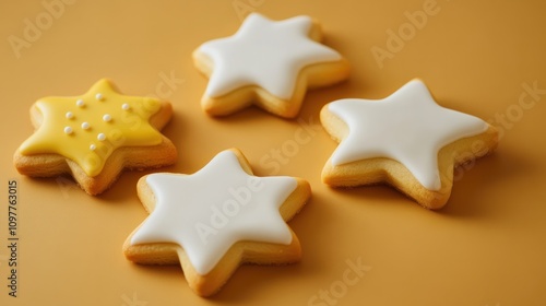 Four white and yellow star shaped cookies with white icing