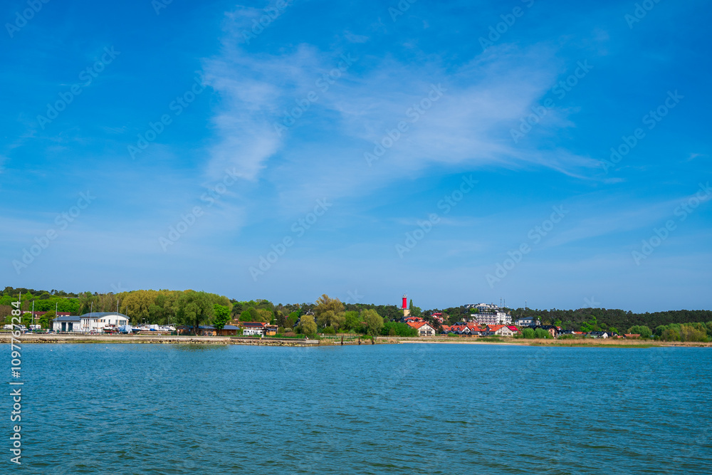 view on Krynica Morska resort with a ferris wheel as seen from a ferry on the Vistula Lagoon view on Krynica Morska resort with a ferris wheel as seen from a ferry on the Vistula Lagoon
