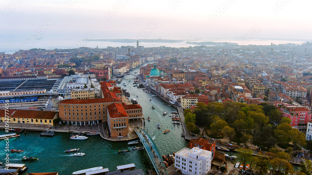Fototapeta premium Enchanting aerial view of Venice’s Grand Canal at sunset, featuring glowing historic buildings and vibrant waterways reflecting the fading light