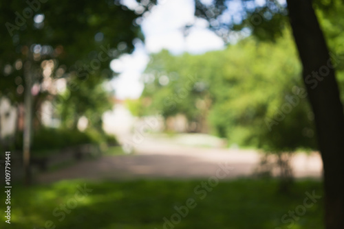 bokeh blurred background of green park in town on a summer day