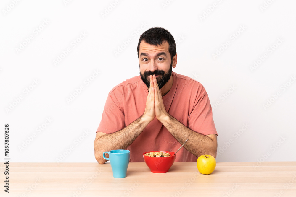 Caucasian man having breakfast in a table keeps palm together. Person asks for something. Caucasian man having breakfast in a table keeps palm together. Person asks for something.