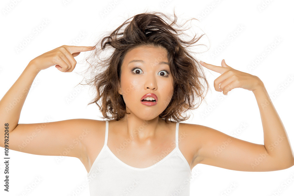 portrait of a confused young asian woman with messy hair on a white background. portrait of a confused young asian woman with messy hair on a white background.
